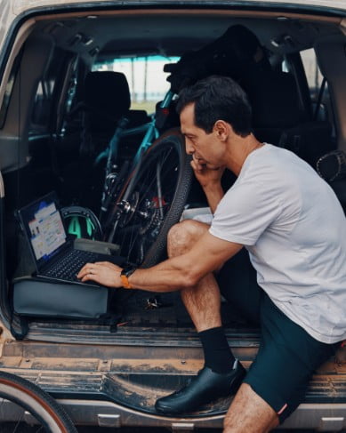 Man working while sitting in the back of open van Man working while sitting in the back of open van