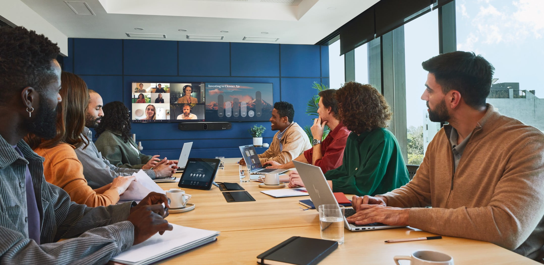 People in a large conference room on a video call