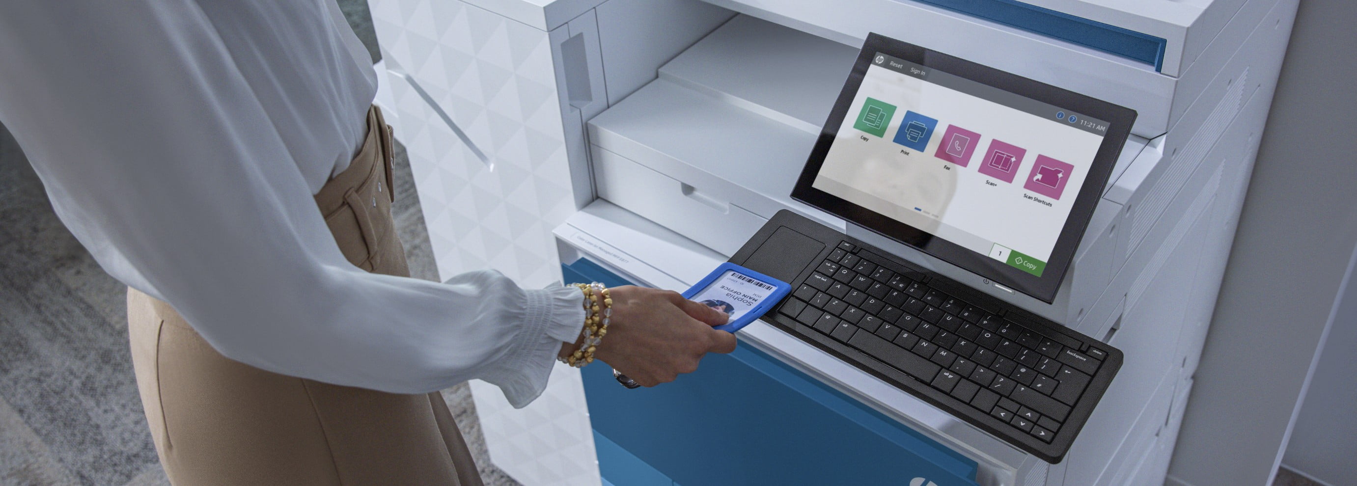 Female office worker scanning badge at LaserJet Enterprise MFP